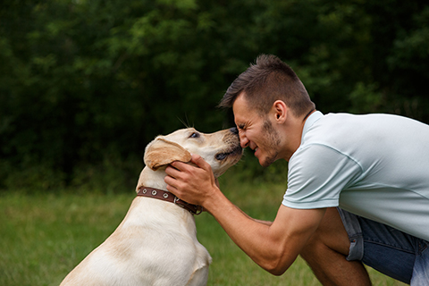 man happy as he enjoys friendship with dog. boosting mental health.