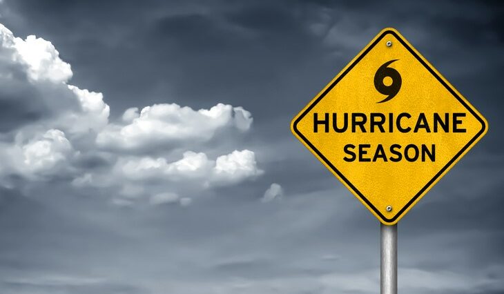 "Hurricane season" sign in front of cloudy skies.