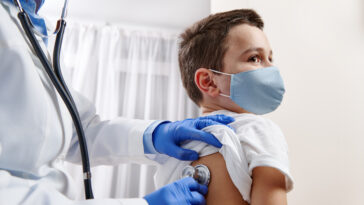 pediatrician using stethoscope to do a checkup on a child