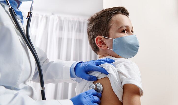 pediatrician using stethoscope to do a checkup on a child