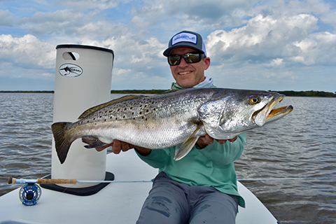 Dr. Wright holding a fish. He is joining the Masson Spine Institute