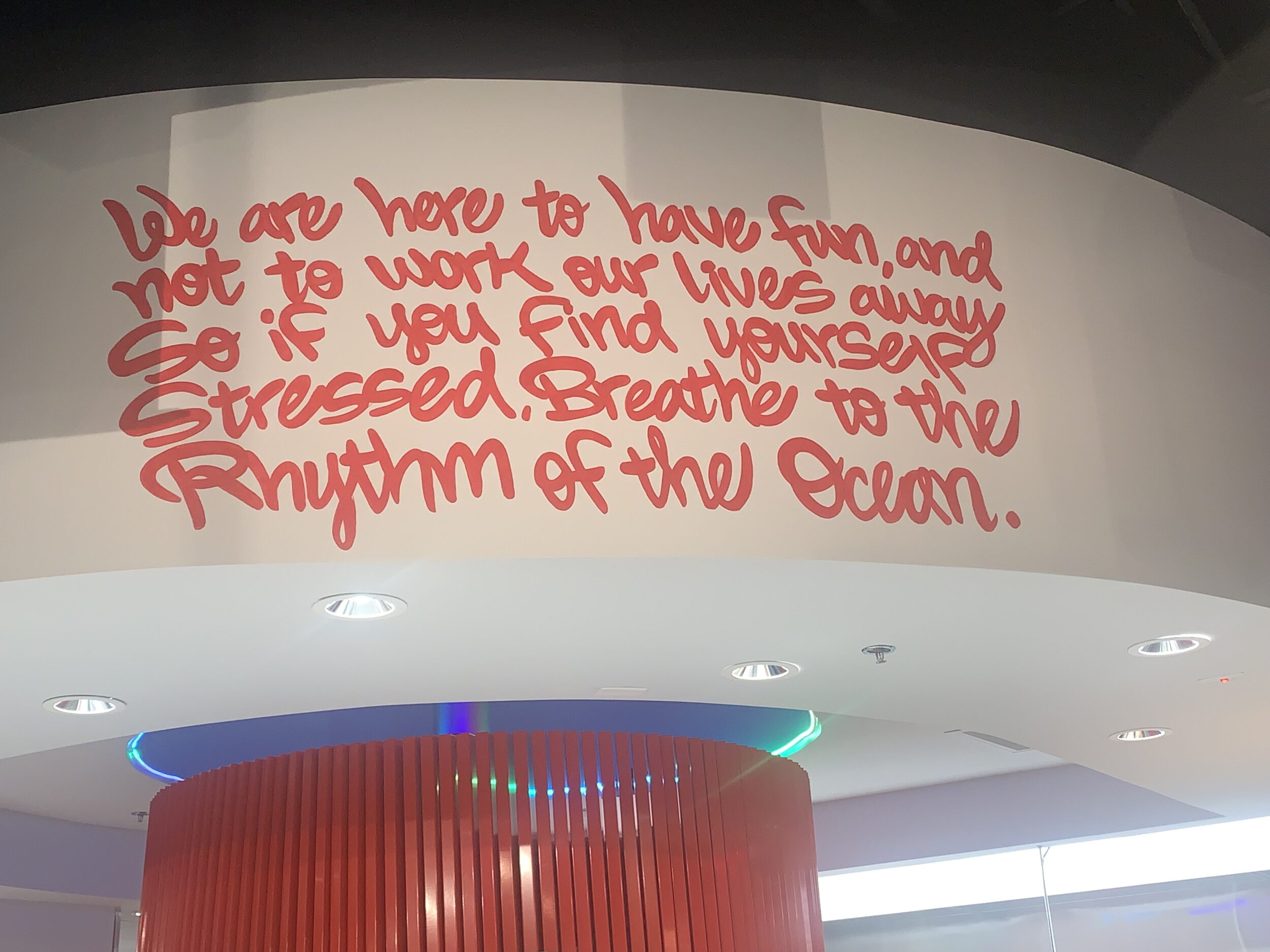 picture of wall art at Playa Pizza. It reads: we are here to have fun, and not to work our lives away so if you find yourself stressed, breathe to the rhythm of the ocean.