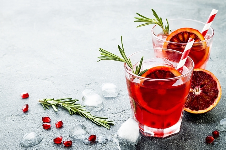 red cocktail with blood orange pomegranate. Refreshing Holiday drink
