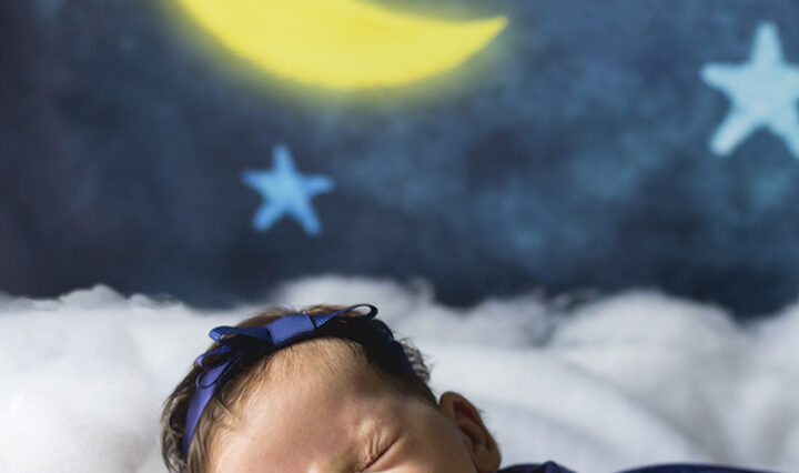 Newborn baby sleeps on clouds.
