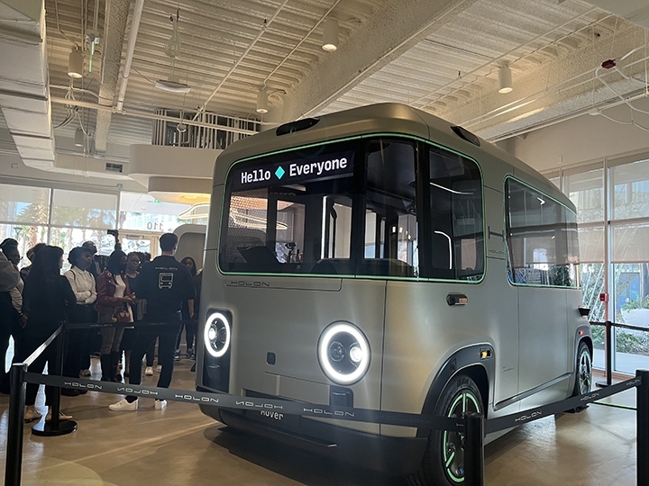 Evan High School students collab with Beep and HFUW and gather around the  small autonomous shuttle