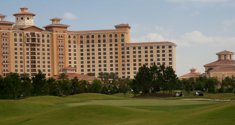 A hotel sits across a green lawn