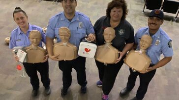 paramedics stand together with cpr dummies