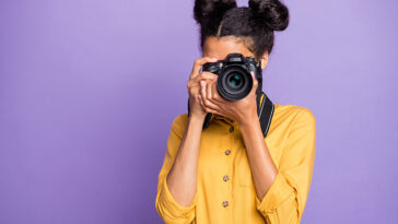 A girl taking a photo with a camera.