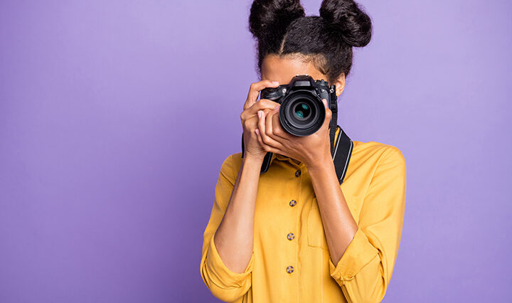A girl taking a photo with a camera.