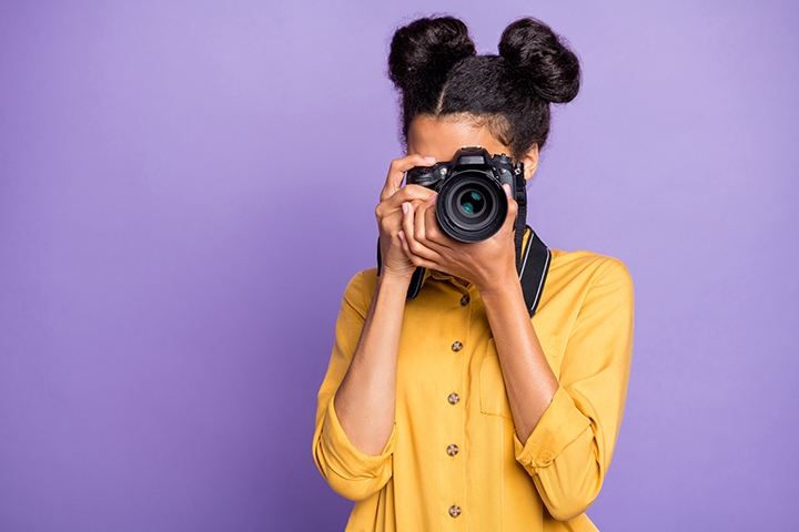 A girl taking a photo with a camera.