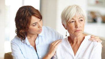 A daughter sitting and checking in on her elderly mother.