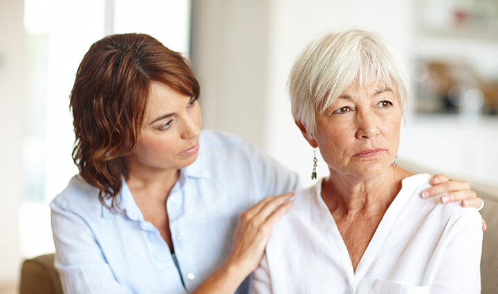 A daughter sitting and checking in on her elderly mother.