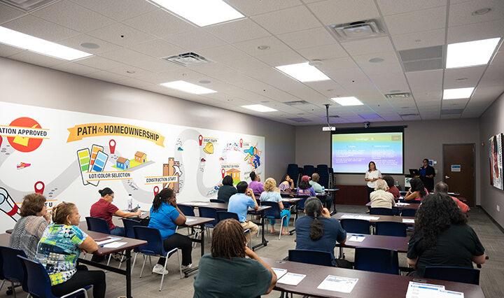 Photo of the community inside a classroom learning with Habitat for Humanity.