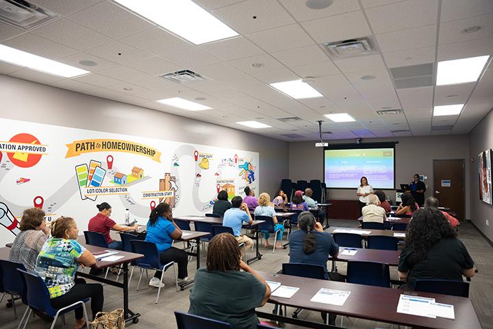 Photo of the community inside a classroom learning with Habitat for Humanity.