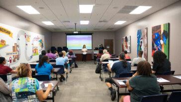 a person is lecturing a room filled with people