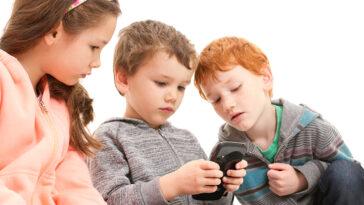 Kids playing games on mobile phone. Learn how social media can impact their mental health.