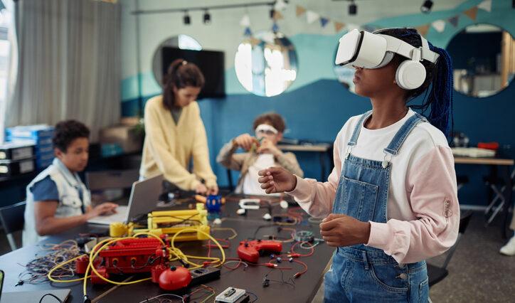 Portrait of young black girl using VR technology in engineering class representing STEM promotion at new East Campus of Orlando Science Charter School.