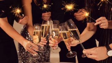 Friends clinking glasses of sparkling wine, closeup. New Year's Eve celebration