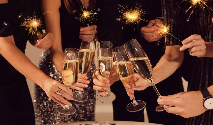 Friends clinking glasses of sparkling wine, closeup. New Year's Eve celebration
