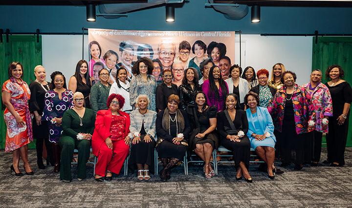 The Black women in Central Florida posing in front of the Legacy of Excellence banner.