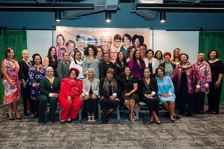 The Black women in Central Florida posing in front of the Legacy of Excellence banner.